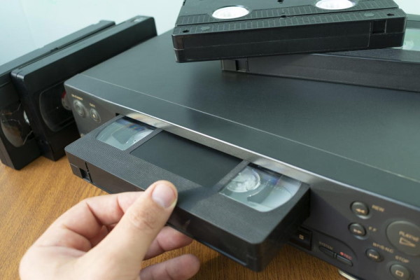 Loading a VHS tape into a VCR